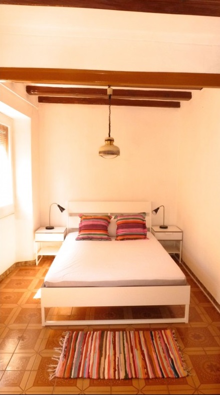 Dormitorio con cama doble y techo con vigas
